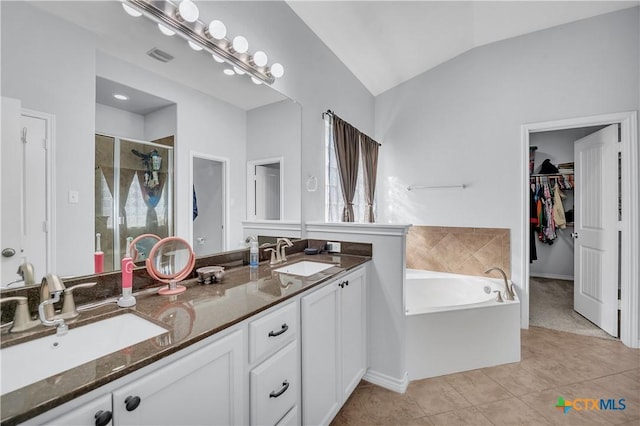 full bathroom with a shower stall, a garden tub, lofted ceiling, and a sink