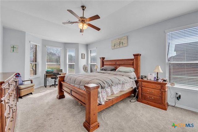 bedroom with a ceiling fan, baseboards, and light carpet