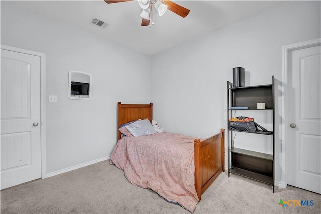 carpeted bedroom with visible vents, a ceiling fan, and baseboards