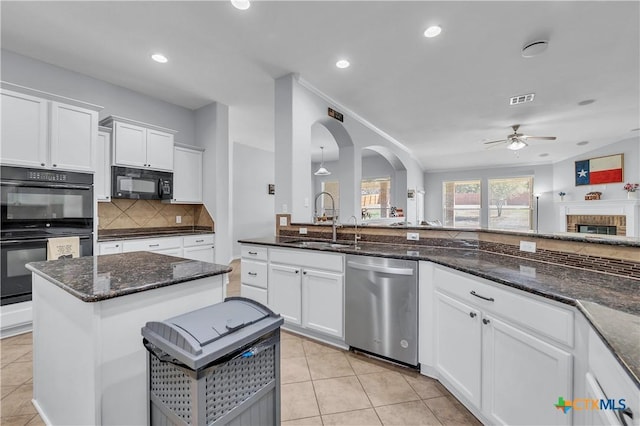 kitchen featuring black appliances, light tile patterned floors, decorative backsplash, white cabinetry, and a sink