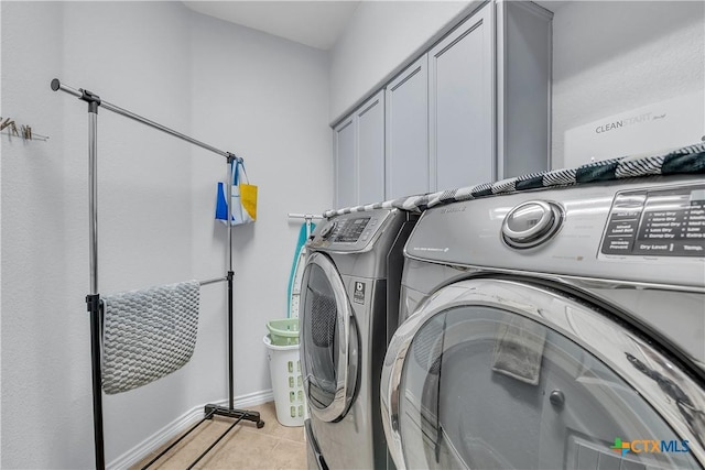 laundry area with light tile patterned floors, cabinet space, and independent washer and dryer