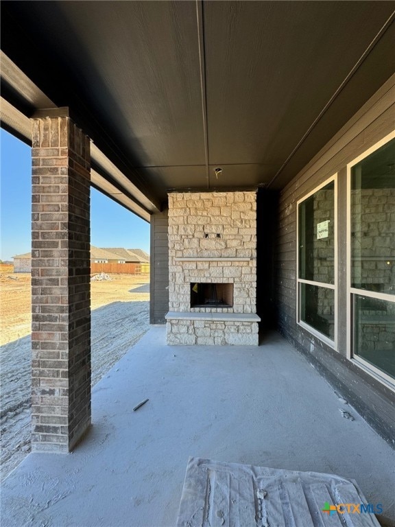 view of patio featuring an outdoor stone fireplace