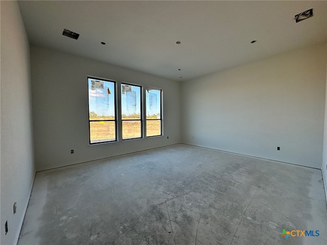 spare room with unfinished concrete flooring