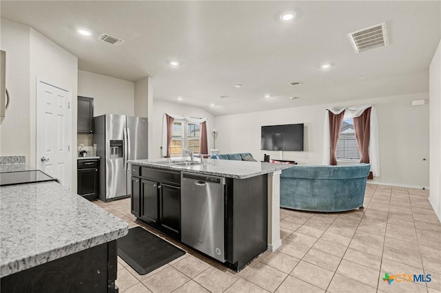 kitchen with a sink, visible vents, appliances with stainless steel finishes, and dark cabinets