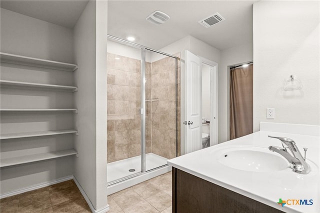 bathroom with tile patterned flooring, visible vents, a stall shower, and a sink