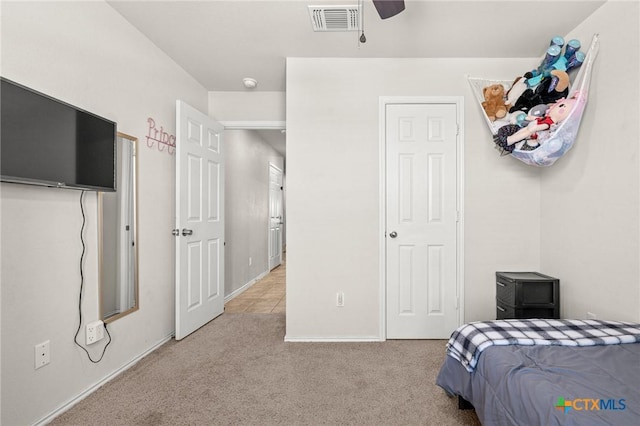 bedroom with visible vents, light colored carpet, and a ceiling fan