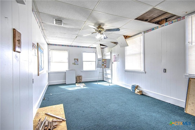 carpeted spare room featuring ceiling fan and a paneled ceiling