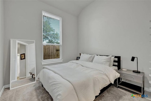 carpeted bedroom featuring vaulted ceiling and baseboards