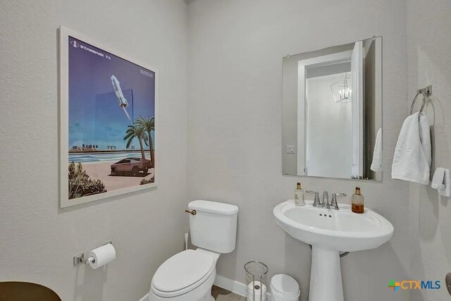 half bathroom with toilet and baseboards