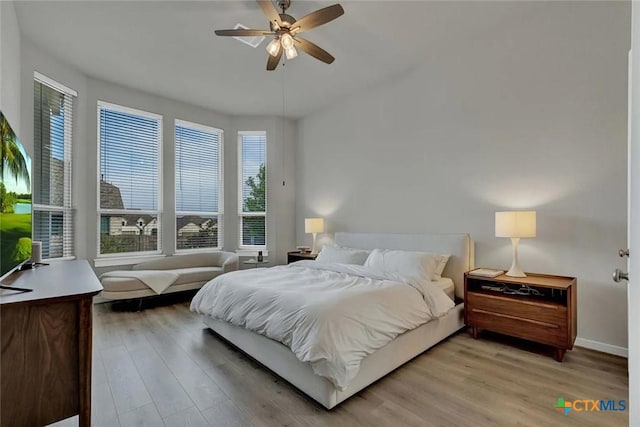 bedroom featuring a ceiling fan, light wood-type flooring, and baseboards