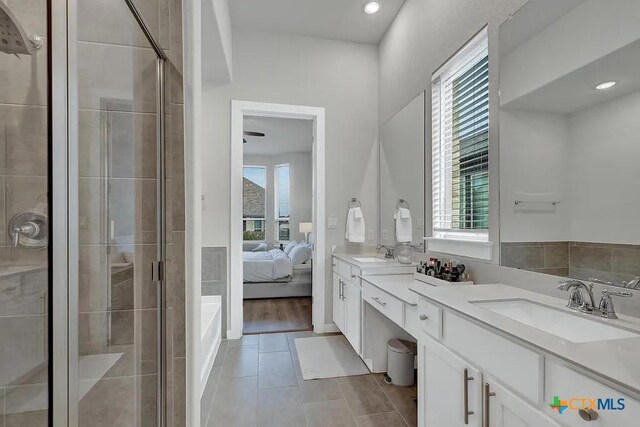 full bathroom featuring plenty of natural light, a stall shower, and a sink