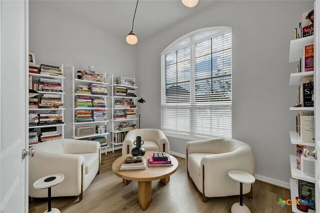 sitting room featuring plenty of natural light, wood finished floors, and baseboards