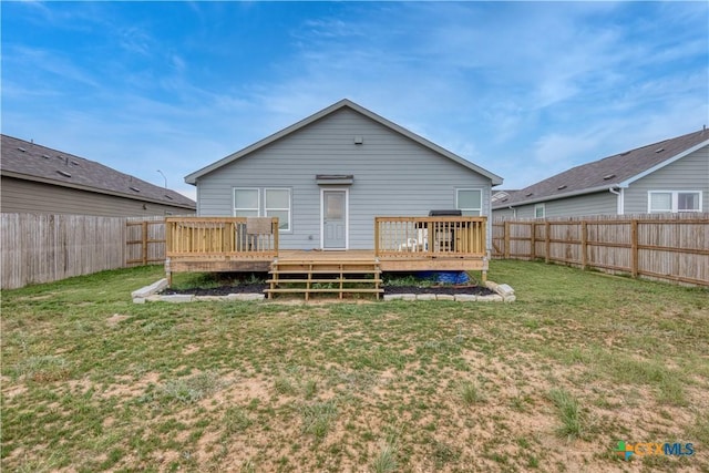 rear view of property with a lawn, a deck, and a fenced backyard