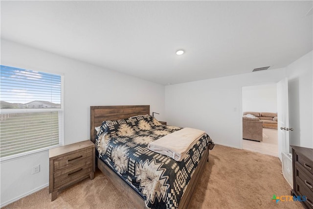 bedroom with light colored carpet, visible vents, and baseboards