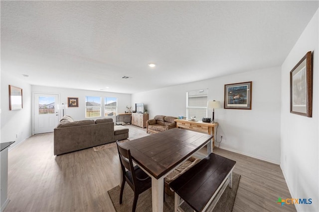 dining area with baseboards, light wood-type flooring, and recessed lighting