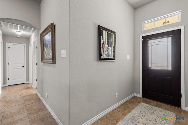 entryway with light tile patterned flooring, visible vents, and baseboards