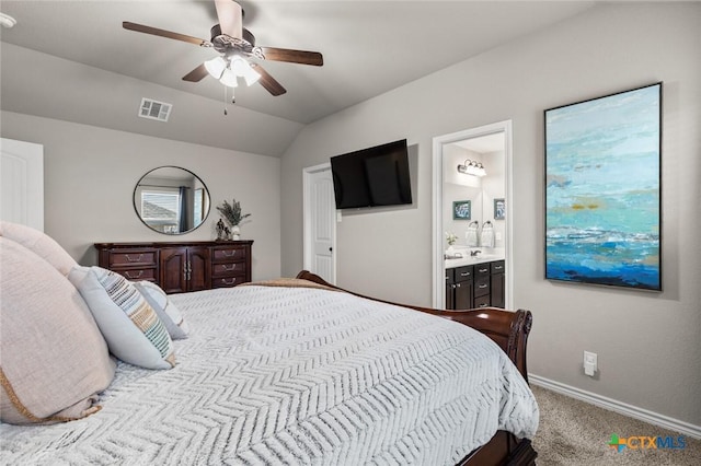 carpeted bedroom with visible vents, baseboards, vaulted ceiling, ensuite bath, and a ceiling fan