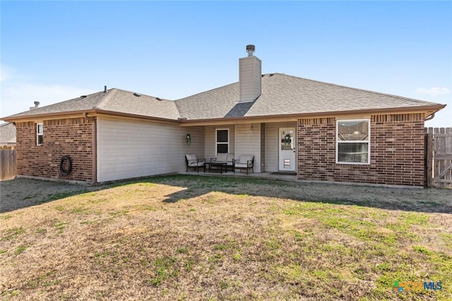 single story home featuring a front yard, fence, a chimney, a patio area, and brick siding