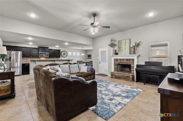 living room featuring recessed lighting, a brick fireplace, and ceiling fan