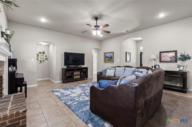 tiled living area featuring visible vents, baseboards, recessed lighting, arched walkways, and ceiling fan