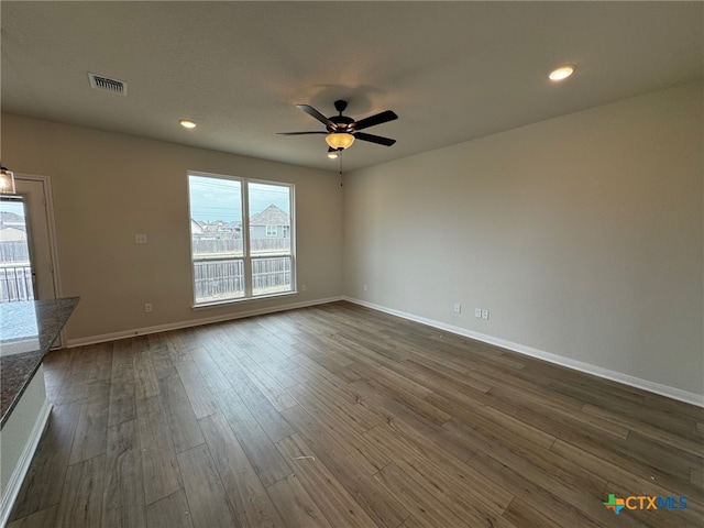 spare room with dark wood-type flooring and ceiling fan