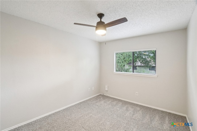 carpeted spare room with a textured ceiling, baseboards, and a ceiling fan