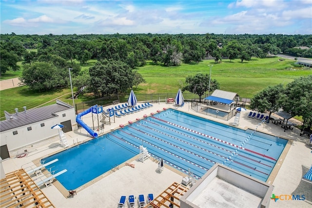 pool with a patio, fence, and a diving board