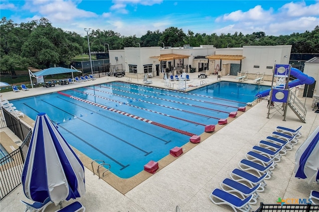 pool with a patio area and fence