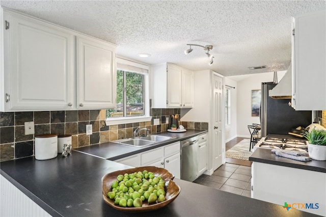 13125 Amarillo Ave, Austin, TX 78729 - kitchen with a sink, tile patterned floors, dishwasher, white cabinets, and dark countertops