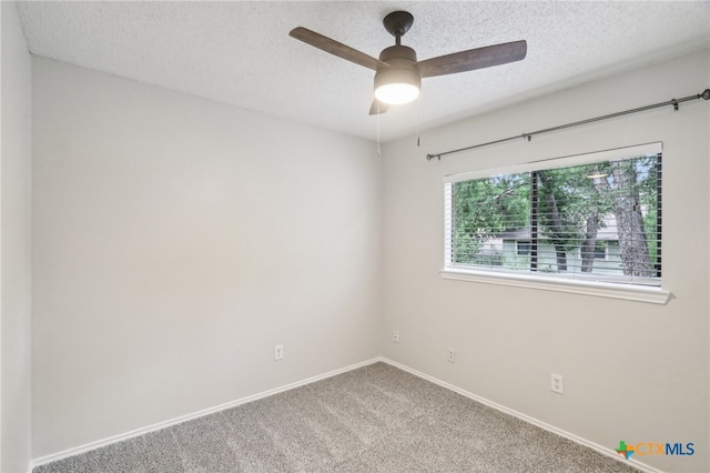 carpeted spare room featuring ceiling fan, a textured ceiling, and baseboards