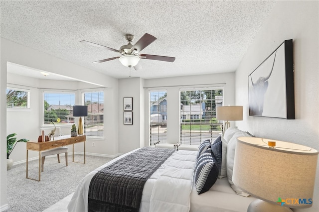 bedroom with a textured ceiling, baseboards, ceiling fan, and carpet floors