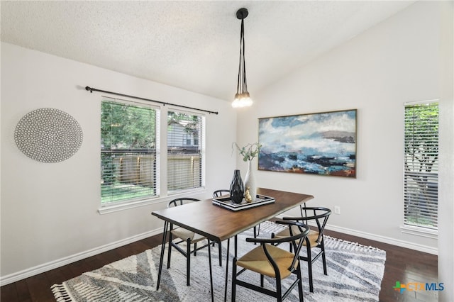 dining space featuring a textured ceiling, baseboards, lofted ceiling, and dark wood-style floors