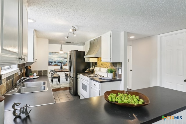 13125 Amarillo Ave, Austin, TX 78729 - kitchen featuring a sink, white gas stove, decorative backsplash, wall chimney exhaust hood, and dark countertops