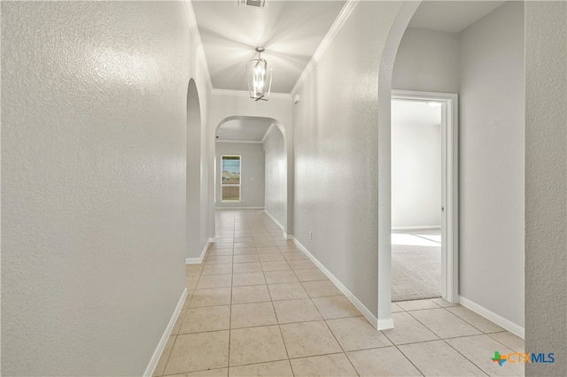 hall with light tile patterned floors and ornamental molding