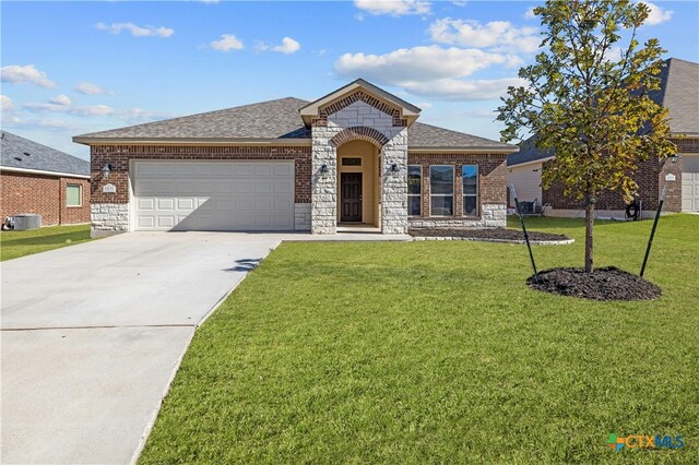 view of front of property featuring cooling unit, a front lawn, and a garage