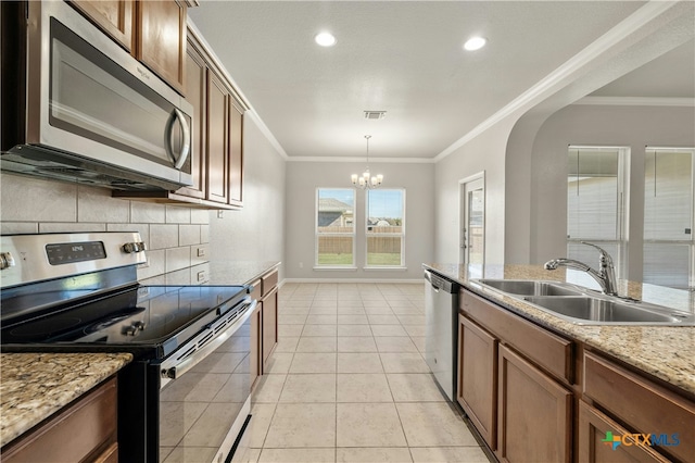 kitchen with sink, an inviting chandelier, pendant lighting, appliances with stainless steel finishes, and ornamental molding