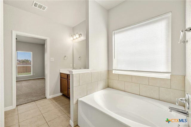 bathroom with tile patterned flooring, vanity, and a bathtub