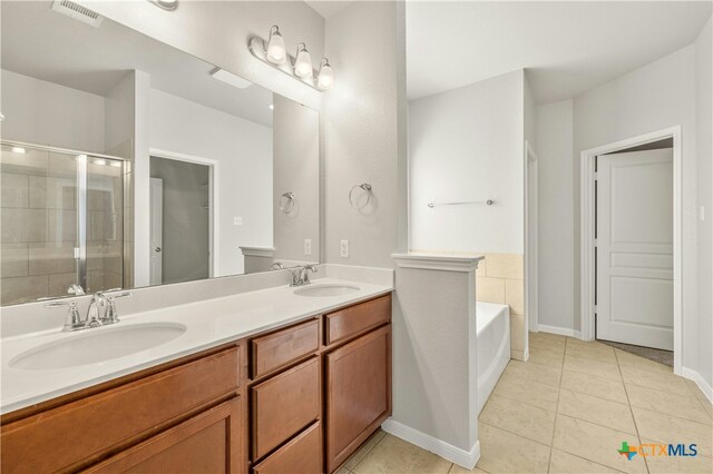 6109 Worthing Dr, Temple, TX 76502 - full bathroom featuring double vanity, a stall shower, tile patterned flooring, a bath, and baseboards