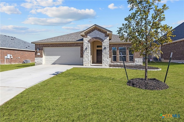 view of front of home featuring a garage, a front yard, and central AC