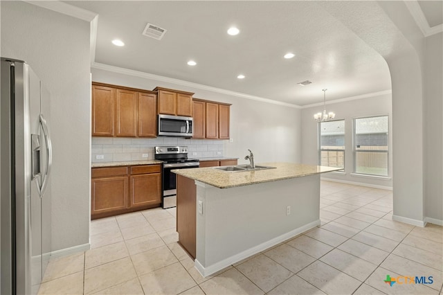 kitchen with stainless steel appliances, a kitchen island with sink, sink, pendant lighting, and light tile patterned floors