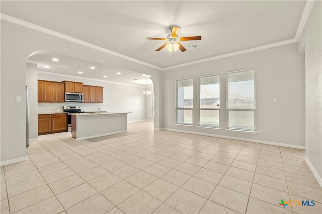 kitchen with ceiling fan, ornamental molding, light tile patterned floors, an island with sink, and stainless steel appliances