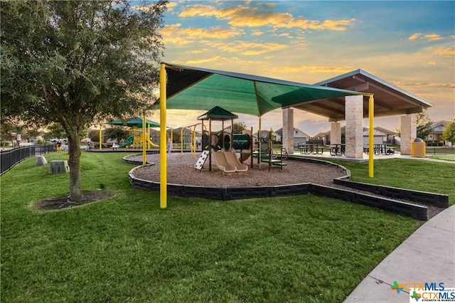 playground at dusk featuring a yard