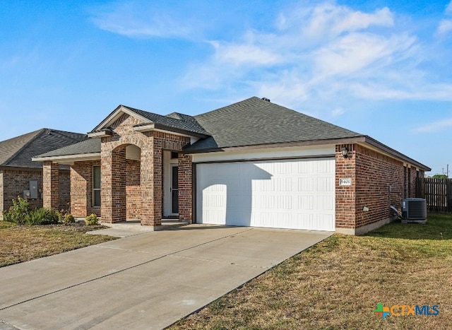 view of front of property with a garage, cooling unit, and a front lawn