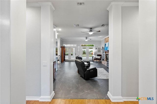 interior space with a glass covered fireplace, visible vents, and crown molding