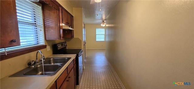 kitchen with ceiling fan, black electric range oven, sink, and a textured ceiling