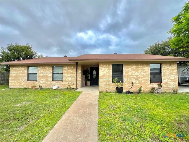 single story home featuring a front lawn