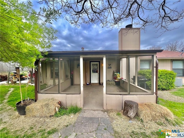 back of property with cooling unit and a sunroom