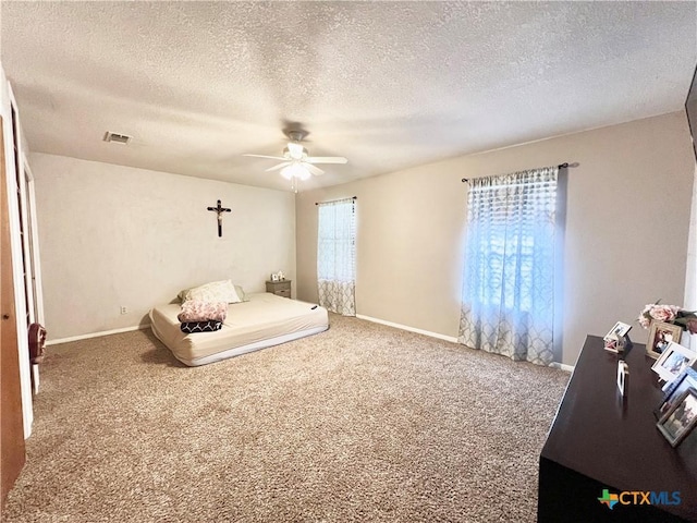 unfurnished bedroom with ceiling fan, carpet, and a textured ceiling