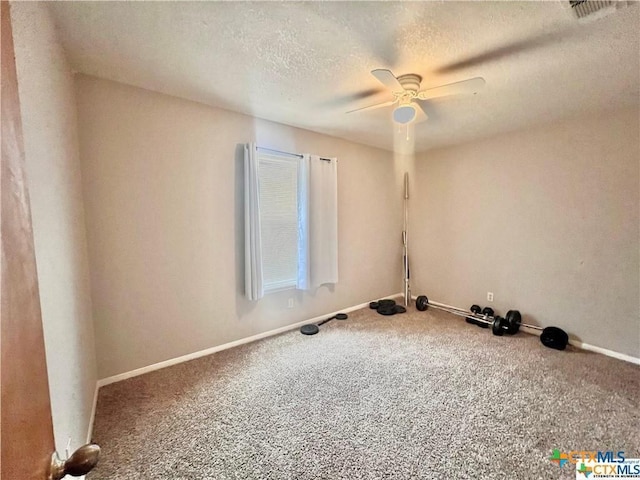 carpeted empty room featuring ceiling fan and a textured ceiling