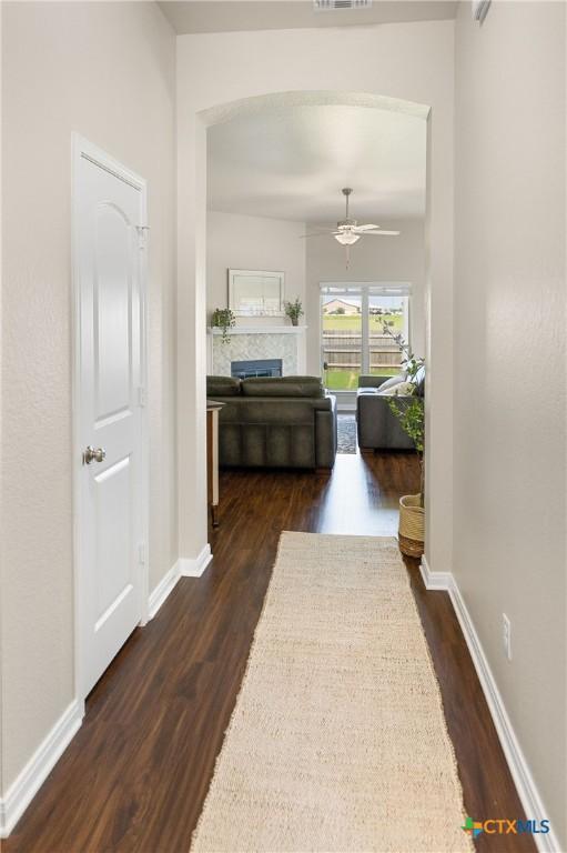 hall with dark wood-style floors and baseboards